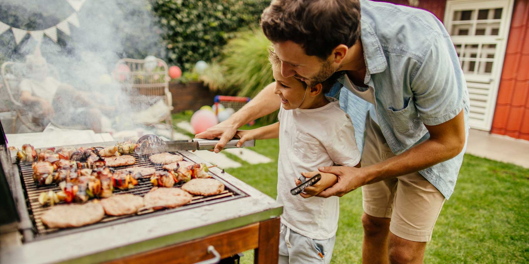 Father and son cooking on a barbecue